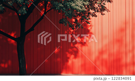 Tree casts a shadow on a red wall. The shadow is long and dark, and the tree is tall and slender. The red wall is a bold and striking contrast to the natural beauty of the tree and its shadow Tree casts a shadow on a red wall. The shadow is long and dark, and the tree is tall and slender. The red wall is a bold and striking contrast to the natural beauty of the tree and its shadow 122834091
