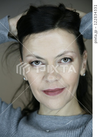 Portrait of attractive middle aged brunette woman 51 years old with evening make-up and natural hair styling 122834331