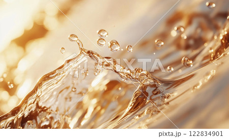 Splash of water with many droplets on a surface. The water is golden in color. Concept of movement and energy Splash of water with many droplets on a surface. The water is golden in color. Concept of movement and energy 122834901