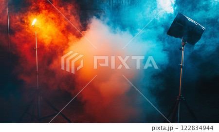 Two lights, one red and one blue, with smoke in the background. The smoke is orange and red, creating a dramatic and intense atmosphere. The lights are positioned in front of the smoke 122834944