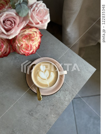 L.atte art tulip flower beautiful. Coffee cup cappuccino and a bouquet of flowers. Hygge lifestyle, cozy mood. Coffee, flower in back light. 122835348