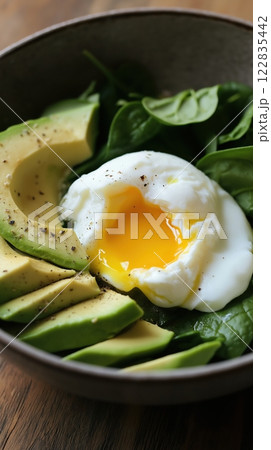 Healthy breakfast bowl with poached egg, sliced avocado, and fresh spinach leaves Healthy breakfast bowl with poached egg, sliced avocado, and fresh spinach leaves 122835442