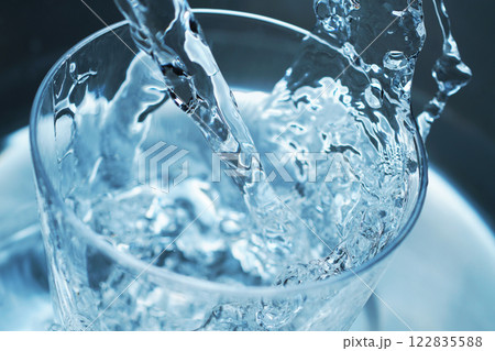 コップに勢い良く注がれた水 122835588
