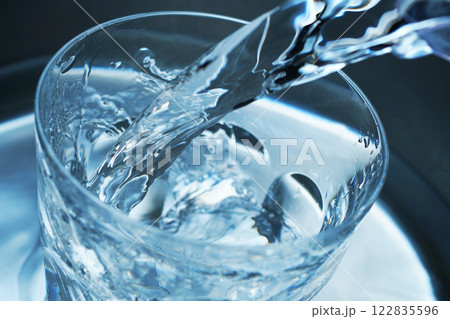 コップに勢い良く注がれた水 122835596
