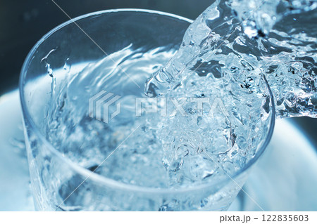 コップに勢い良く注がれた水 122835603