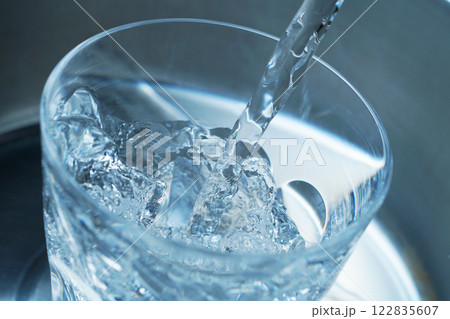 コップに勢い良く注がれた水 122835607