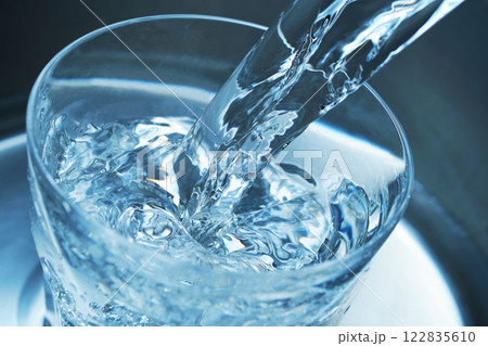 コップに勢い良く注がれた水 122835610