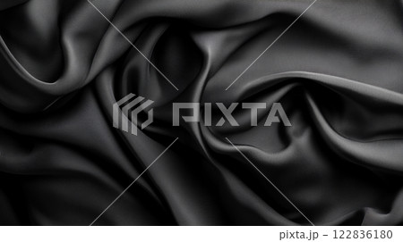 Black fabric with a pattern that is not visible. The fabric is long and has a smooth texture Black fabric with a pattern that is not visible. The fabric is long and has a smooth texture 122836180