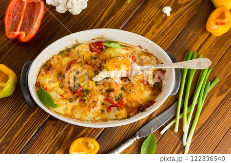 cauliflower baked with sweet pepper and vegetables under cheese 122836540