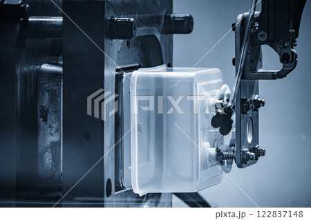 Close up scene material handling process the food container by robotic system from injection machine. 122837148