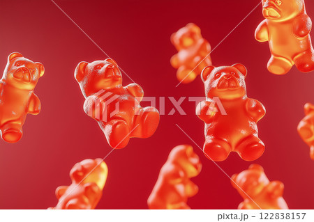 Red gummy bears floating in air on a vibrant red background. Gummy bear candies suspended in mid-air over bright backdrop. Sweets and happy childhood concept. 122838157