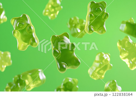 Green gummy bears floating in air on a vibrant green background. Gummy bear candies suspended in mid-air over monochromatic green backdrop. Sweets and happy childhood concept. Green gummy bears floating in air on a vibrant green background. Gummy bear candies suspended in mid-air over monochromatic green backdrop. Sweets and happy childhood concept. 122838164