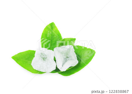 Pieces of alum stone on green leaf against white background. This image emphasizes the connection between natural minerals and plant based ingredients in traditional practices and holistic wellness. 122838867
