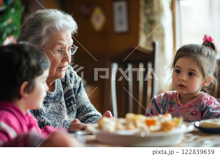 Grandmother sharing stories with young children in a cozy setting during a sunny afternoon 122839639