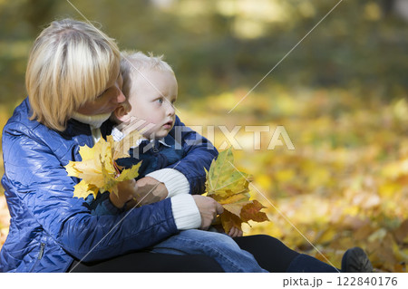 Mother and little son on a walk in the park. 122840176