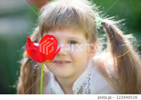 Creative portrait of a little girl with a tulip. Creative portrait of a little girl with a tulip. 122840526