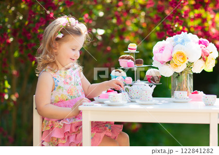 Kids having fun at garden tea party Kids having fun at garden tea party 122841282