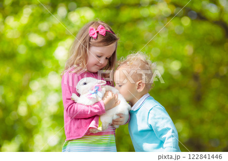 Little girl playing with rabbit Little girl playing with rabbit 122841446