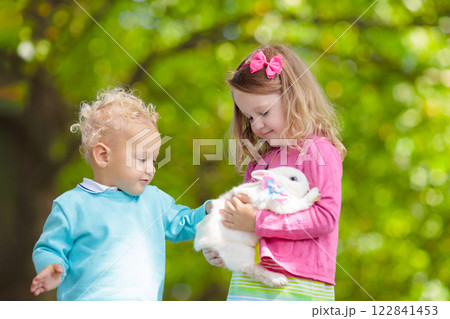 Little girl playing with rabbit 122841453