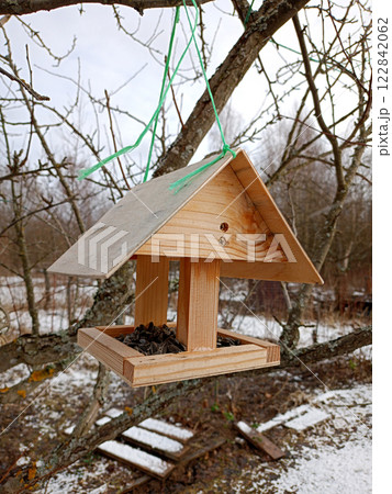 Wooden bird feeder with sunflower seeds 122842062