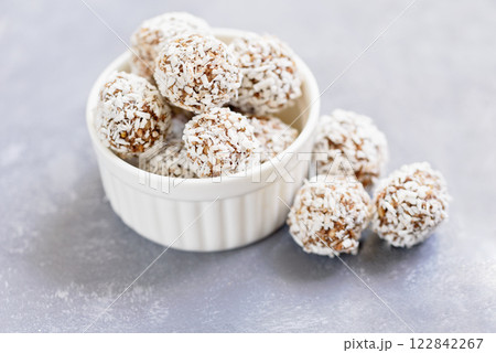 Healthy raw energy balls with cocoa, coconut, sesame, chia on white background. Healthy homemade paleo chocolate energy balls with rolled oats, nuts, dates. Raw vegan healthy dessert, selective focus Healthy raw energy balls with cocoa, coconut, sesame, chia on white background. Healthy homemade paleo chocolate energy balls with rolled oats, nuts, dates. Raw vegan healthy dessert, selective focus 122842267