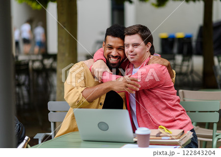 Young man with Down syndrome hugging his special educator teacher. 122843204