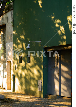 A green building features a bright light located on its side A green building features a bright light located on its side 122844086