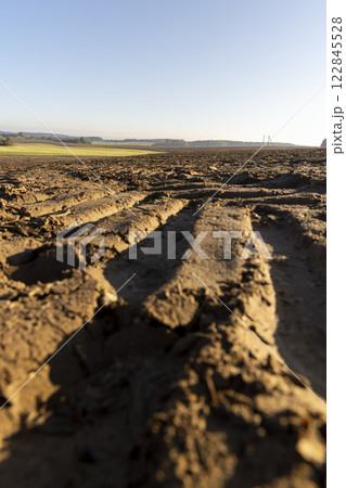 traces of tractors and other agricultural machinery on the soil in the field traces of tractors and other agricultural machinery on the soil in the field 122845528