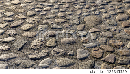 a part of the road made of cobblestones, an old-style pavement 122845529