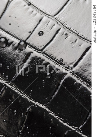 polished leather dyed black with embossed crocodile leather covered with water droplets polished leather dyed black with embossed crocodile leather covered with water droplets 122845564