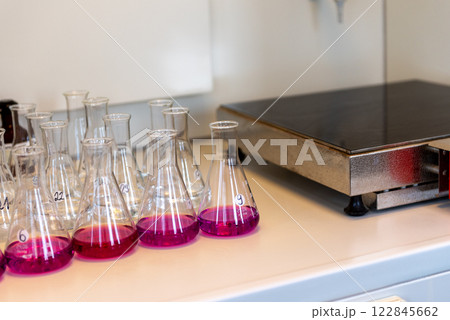 Rows of Erlenmeyer flasks filled with permanganate. Laboratory equipment Rows of Erlenmeyer flasks filled with permanganate. Laboratory equipment 122845662