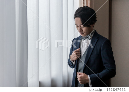控え室・ブライズルームで結婚式・挙式・披露宴の準備をする新郎・花婿（タキシード） 122847431