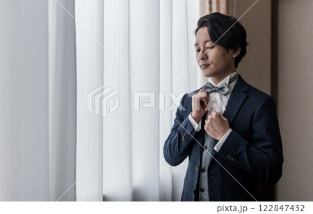 控え室・ブライズルームで結婚式・挙式・披露宴の準備をする新郎・花婿（タキシード） 122847432
