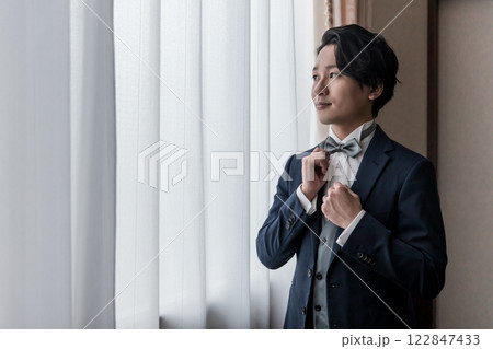 控え室・ブライズルームで結婚式・挙式・披露宴の準備をする新郎・花婿(タキシード) 控え室・ブライズルームで結婚式・挙式・披露宴の準備をする新郎・花婿(タキシード) 122847433