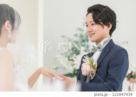 結婚式場で指輪交換する新郎新婦(結婚式・ウェディング・ブライダル) 結婚式場で指輪交換する新郎新婦(結婚式・ウェディング・ブライダル) 122847439