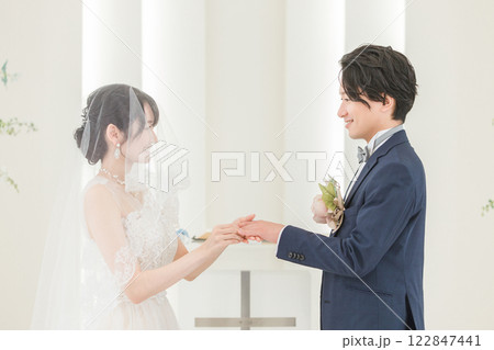 結婚式場で指輪交換する新郎新婦（結婚式・ウェディング・ブライダル） 122847441