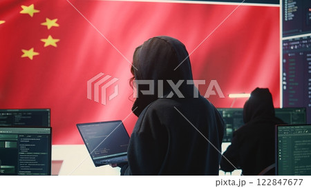 Chinese hacker working in governmental hacking room with Chinese flag on a big screen. Having the mission on inflicting fear and misinformation among the population. Dictatorship propaganda. Camera B. Chinese hacker working in governmental hacking room with Chinese flag on a big screen. Having the mission on inflicting fear and misinformation among the population. Dictatorship propaganda. Camera B. 122847677