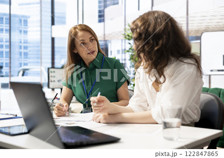 Teamworking recruiters doing brainstorming, hiring for newly opened company position, looking over CVs matching job description. HR expert and colleague analyzing candidates resumes 122847865