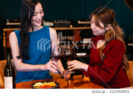 レコードで音楽が楽しめるおしゃれなバーで乾杯する若い女性 122848691