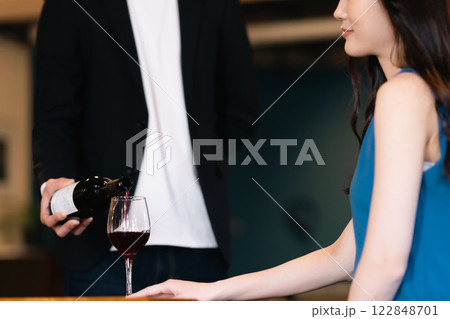 ワインを注ぐウェイターと注がれるのを待つ女性 顔無し ワインを注ぐウェイターと注がれるのを待つ女性 顔無し 122848701