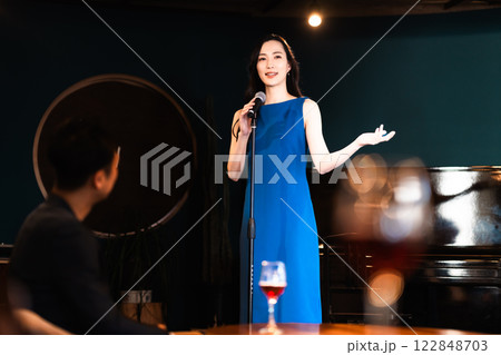 ライブ演奏がある飲食店で歌う若い女性とお客様 122848703