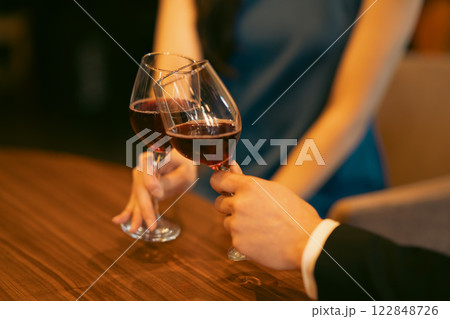 おしゃれなレストランでワイングラスを傾ける男女 顔無し おしゃれなレストランでワイングラスを傾ける男女 顔無し 122848726
