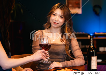 レコードで音楽が楽しめるおしゃれなバーでワインを楽しむ若い女性 122848735