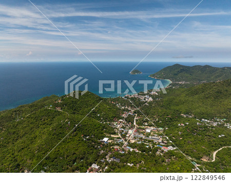 Coastal landscape with lush green hills, small islands in the distance, and a clear blue sky over turquoise waters. Koh Tao, Thailand. 122849546