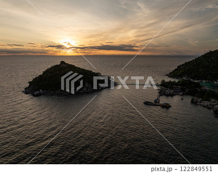 Small islands surrounded by calm sea during sunset, with a pier and vibrant sky. Koh Tao, Thailand. 122849551