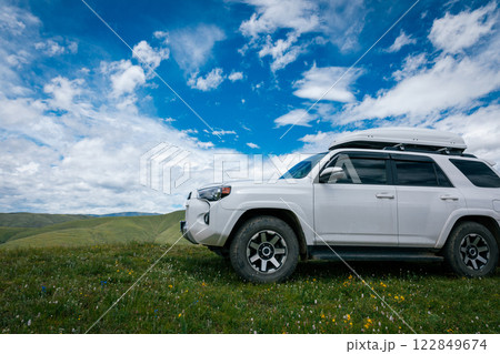 Offroad car on grassland mountain under blue sky 122849674