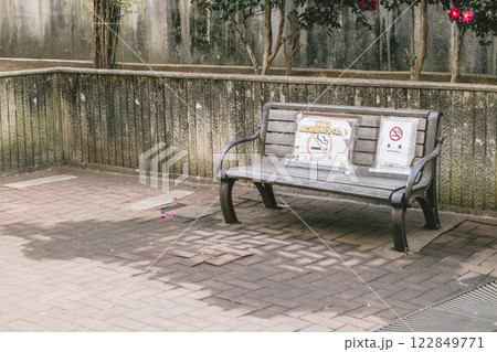 レトロな古ぼけた公園 禁煙の張り紙をされたベンチ レトロな古ぼけた公園 禁煙の張り紙をされたベンチ 122849771