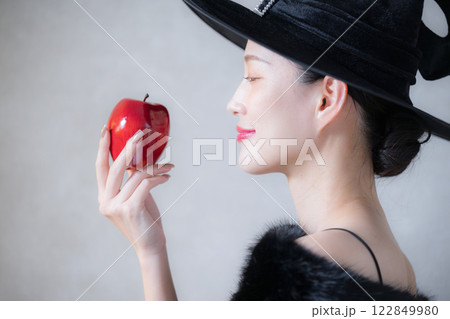 かわいいヴィラン(悪役)や魔女のイメージ　ハロウィンやコスプレの横顔　林檎を食べる 122849980