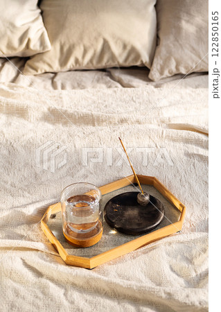 Smoldering Incense and Glass of Water on Tray in Bedroom. Morning Ritual. 122850165