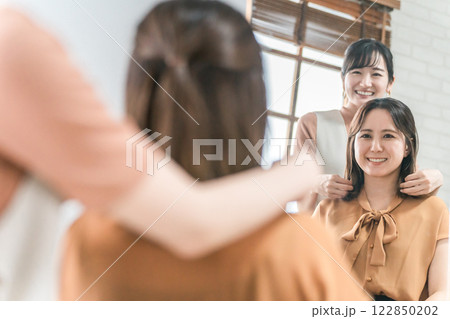 美容室・ヘアサロンで髪型を相談するアジア人女性の客とカウンセリングする美容師・スタイリスト 美容室・ヘアサロンで髪型を相談するアジア人女性の客とカウンセリングする美容師・スタイリスト 122850202